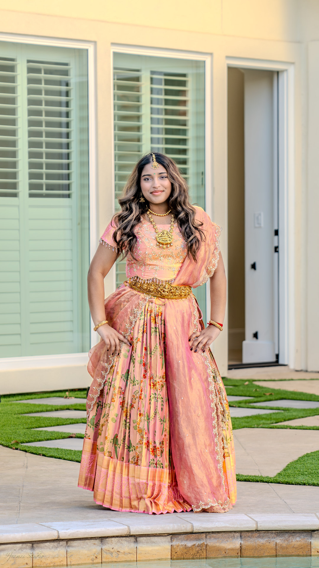 Anushka in a pink and gold outfit on the garden path